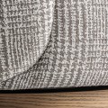 Luxusn&eacute; art deco okr&uacute;hle otočn&eacute; kreslo Elvara so vzorovan&yacute;m sivo bielym poťahom a okr&uacute;hlou drevenou hnedou podstavou 85 cm