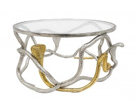 Dizajnov&yacute; art deco konferenčn&yacute; stol&iacute;k Tierra Glam s okr&uacute;hlou sklenenou priehľadnou doskou a podstavou z kovu v striebornej farbe so zlat&yacute;m akcentom v tvare troch prepleten&yacute;ch kobier
