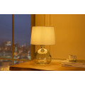 Modern&aacute; sklenen&aacute; stoln&aacute; lampa Glassy s asymetrickou transparentnou nohou a bielym textiln&yacute;m tienidlom 42 cm