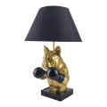 Moderná dizajnová stolná lampa Pop Atelier s podstavou z polyresinu v zlatej farbe v podobe polfigúry buldoga v boxerskej póze s rukavicami a podstavcom v čiernej farbe s kužeľovitým čiernym textilným tienidlom