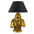 Moderná stolná lampa Pop Atelier s čiernym okrúhlym tienidlom z textilu s rozšírenou spodnou časťou a podstavou v podobe sochy polfigúry opice v pop art štýle s boxerskými rukavicami v zlatom prevedení