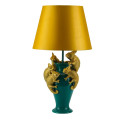 Glamour stolná lampa Tierra Glam so zelenou podstavou v tvare vázy s piatimi dekoratívnymi figúrami chameleónov vo vrchnej časti v zlatej farbe s okrúhlym tienidlom s rozšírenou spodnou časťou z textilu v zlatožltej farbe