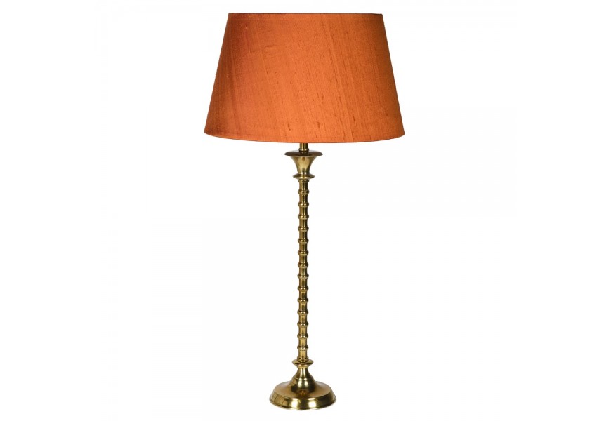 Štýlová vintage stolná lampa Impala s ozdobnou kovovou podstavou zlatej farby a s oranžovým tienidlom