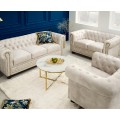 Dizajnová glamour zostava nábytku do obývačky Contessa s čalúnenými sedačkami a kreslom s chesterfield prešívaním v krémovej farbe a stolíkmi s mramorovými doskami v bielej farbe so sivým žilkovaním s kovovými podstavami v zlatej farbe