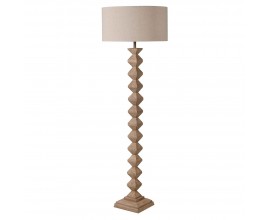 Dizajnov&aacute; stojaca lampa Quart vo vidieckom &scaron;t&yacute;le s valcov&yacute;m tienidlom v b&eacute;žovej farbe a s drevenou vyrez&aacute;vanou nohou v hnedej farbe