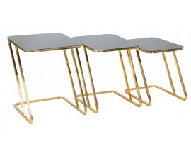 Art deco sada pr&iacute;ručn&yacute;ch stol&iacute;kov Aurialis s čiernymi sklenen&yacute;mi vrchn&yacute;mi doskami v elegantnom obdĺžnikovom tvare a lesklou zlatou kovovou kon&scaron;trukciou v tvare Z