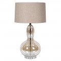 Dizajnová glamour stolná lampa Kayla s nohou z priehľadného skla s hnedým tónovaním so zaoblenou siluetou v tvare hrušky s okrúhlym béžovým ľanovým tienidlom a kovovou konštrukciou v lesklom chrómovom prevedení
