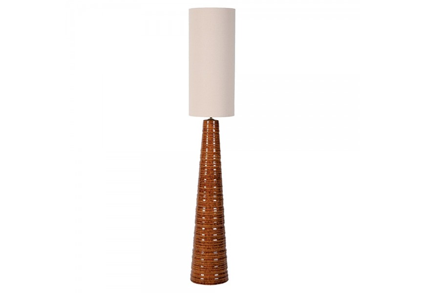 Dizajnová keramická stojaca lampa Nabia so štíhlou kužeľovitou nohou s horizontálnym drážkovaním v karamelovej hnedej farbe s lesklou glazúrou s vysokým ľanovým valcovitým tienidlom v bielej farbe
